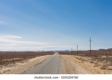 View of a desert landscape with a dirt road and sheep farming in the Karoo of South Africa - Shutterstock ID 1035204760