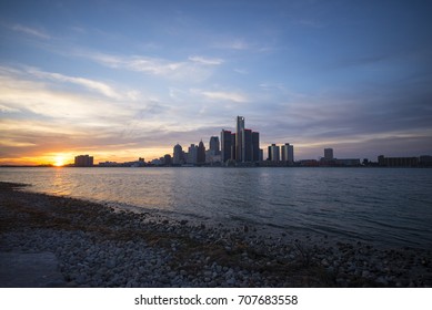 View of Detroit city skyline at sunset from the shore of the river on the canadian side