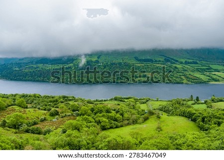View from the Devils Chimney Waterfall area toward Glencar Lough in northwest Ireland. Misty green valley, lake and cliffs in the Sligo Leitrim border landscape, Ireland