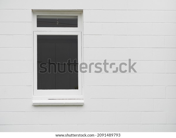 View of divided vertical awning window on\
white brick wall. Copy space stock\
photo.