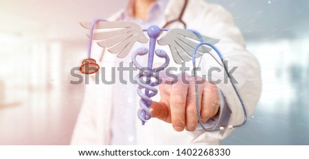 View of a Doctor holding a 3d redering medical cadaceus and stethoscope