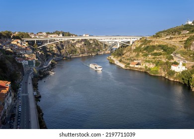 A View Of The Douro River With A Sailing Cruise Ship And The Bridges In Porto