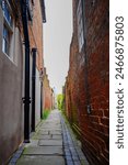 View down an alleyway in with red brick walls