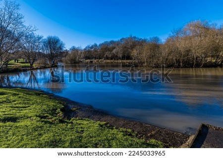 A view down the boating lake in the central park in Corby, Northampton, UK on a bright winters day