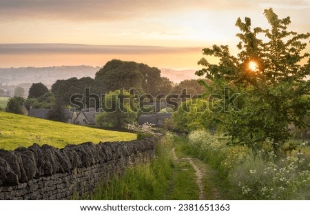 View down a country track towards thatched cottages at Broad Campden, Cotswolds, England