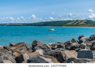 A view down the harbour wall over the West Beach and headland in New Quay, Wales in summertime