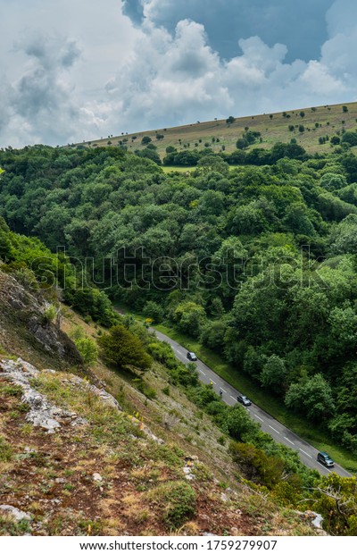 View\
down onto Cliff Road at the Cheddar Gorge near Bristol in North\
Somerset.  One car can just be seen driving along the bendy winding\
A road.  Trees, cliffs and nature frame the\
image