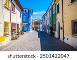 A view down a quiet, deserted, colourful street in the village area of San Giuliano in Rimini, Italy in summertime