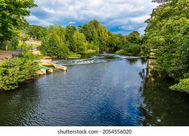 A view down the River Aire on the outskirts of the model village of Saltaire, Yorkshire, UK in summertime