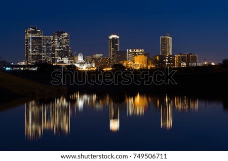 View of Downtown Fort Worth at twilight a city park with the Trinity River reflecting the skyline