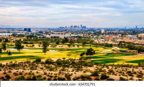 View of downtown Phoenix under cloudy sky from one of the red sandstone buttes of Papago Park in the city of Tempe, Arizona in the United States of America