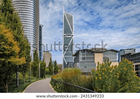 View of a downtown skyscrapers with trees and a path in a park in the SOMA neighborhood in San Francisco, California