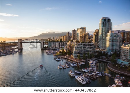 View of Downtown Vancouver and Burrard Bridge at False Creek during sunny sunset.