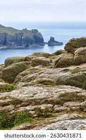 The view of Dr Syntax's Head through the bare rocks on the foreground. Land's End. Penwith peninsula. Cornwall. England. Great Britain