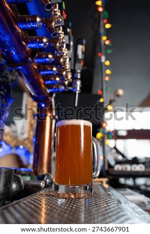View of draft beer mug under bar taps.