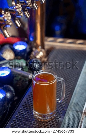 View of draft beer mug under bar taps.