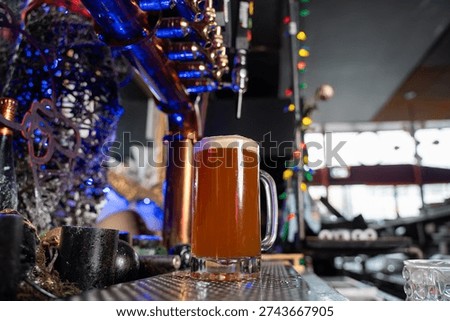 View of draft beer mug under bar taps.