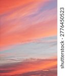 ​Panoramic view of a dramatic sunset sky with wispy clouds and vibrant colors. Serene evening atmosphere with a colorful cloudscape during the golden hour.
