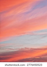 ​Panoramic view of a dramatic sunset sky with wispy clouds and vibrant colors. Serene evening atmosphere with a colorful cloudscape during the golden hour.