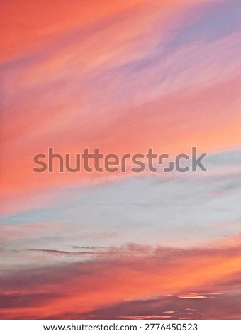 ​Panoramic view of a dramatic sunset sky with wispy clouds and vibrant colors. Serene evening atmosphere with a colorful cloudscape during the golden hour.