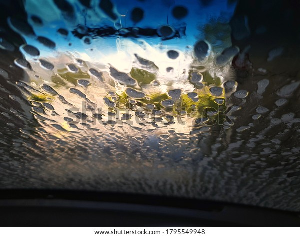 View of\
drive through car wash, from car interior\
