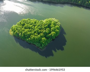 View From The Drone To The Island Formed In The Form Of A Green Heart Surrounded By Water, A Lake. Beautiful Landscape With A Drone On An Interesting Lake