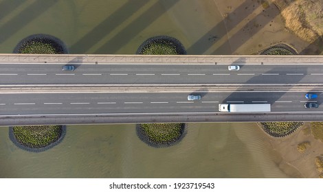 View From A Drone Looking Down On Traffic On A Road Bridge Crossing A Large River In Suffolk, UK