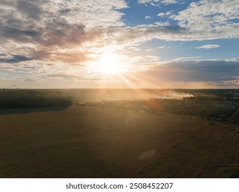 View from drone, panorama view of the forest and fields, top view, orange sky and gray clouds, sun at sunset