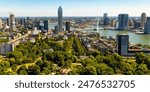 View from drone of Rotterdam city overlooking modern districts with high skyscrapers and Erasmus cable-stayed bridge across Nieuwe Maas river on sunny summer day, Netherlands..