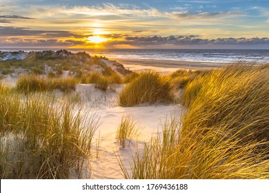 View from dune top over sunset in North Sea from the island of Ameland, Friesland, Netherlands - Powered by Shutterstock