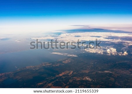 View of the earth through the clouds. Flight over lakes and forests. 