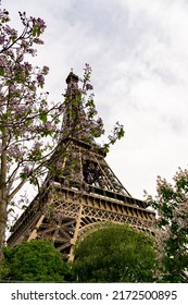 View of the Effiel Tower from below surrounded by flowering trees in springtime in Paris, France.