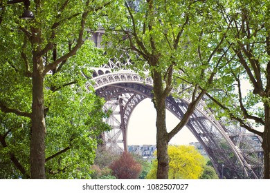 View of the Eiffel tower’s base structure through trees, Paris France.
