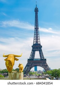 View of the Eiffel Tower from the Trocadero Square with sculptures in the foreground in Paris.