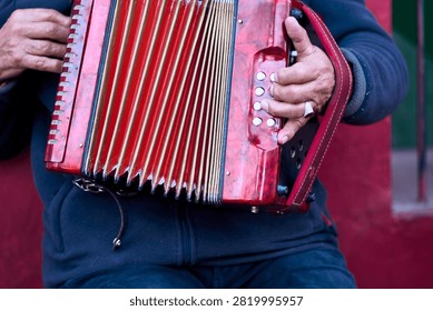 A view of an elderly man's hands playing the accordion with enthusiasm outdoors, his fingers moving gracefully across the keys, a true virtuoso. Nostalgia, old age, elder, gratitude.                               