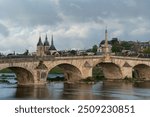 View of the embankment with ancient houses and the Jacques Gabriel Bridge over the Loire River on a sunny summer day, Blois, Loire and Cher, France