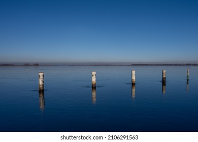A view of empty docks in the winter. Blue water and a clear blue sky