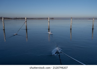 A view of empty docks in the winter. Blue water and a clear blue sky