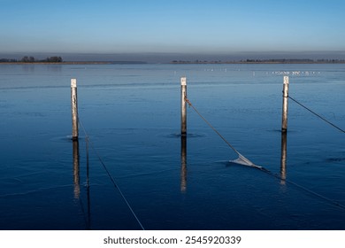 A view of empty docks in the winter. Blue water and a clear blue sky - Powered by Shutterstock