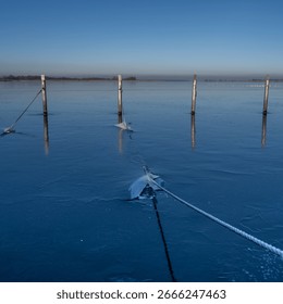 A view of empty docks in the winter. Blue water and a clear blue sky