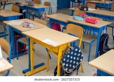View of an empty elementary school classroom, with tables and seats. Concept of education in France, back to school.