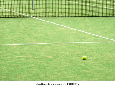 View of empty lawn tennis court with tennis ball