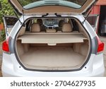 View of the empty open trunk cargo area of a white crossover vehicle with the rear seats and parcel shelf visible