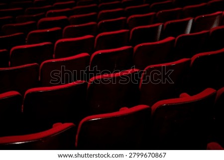View of empty red theater seats in auditorium.