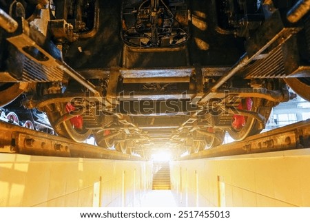 View of the engine undercarriage from the bottom of the inspection pit. Wheels of an old locomotive train locomotive from below