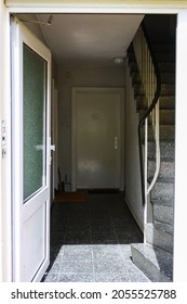 View Of Entrance Of Cheap Apartment In Itzehoe, Germany With Door Open And Staircase In Summer. No People.