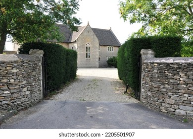 View of an entrance and courtyard of a beautiful stone house on a street in an English town - Shutterstock ID 2205501907