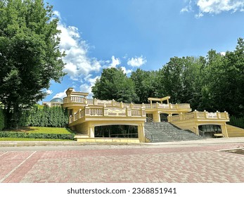 A view of the entrance to the stairs of a modern spa hotel in the middle of a green park on a sunny summer day in a tourist resort. Summer vacation in a luxury hotel in the middle of nature.