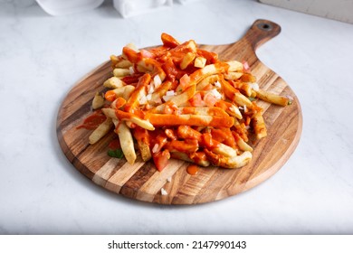 A View Of An Entree Of Loaded French Fries, Topped With Hot Sauce.