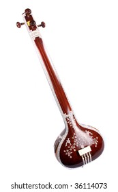 A view of an ethnic Indian string instrument called as the Tanpura / Sitar, isolated on a white background. The base of the instrument is made of a huge pumpkin beautiful carved in floral design.